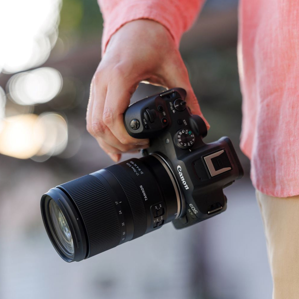 Person holding a Canon camera with a blurred background